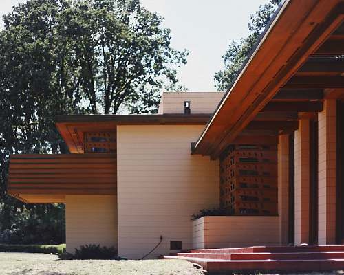 wood white concrete house surrounded with tall and green trees porch
